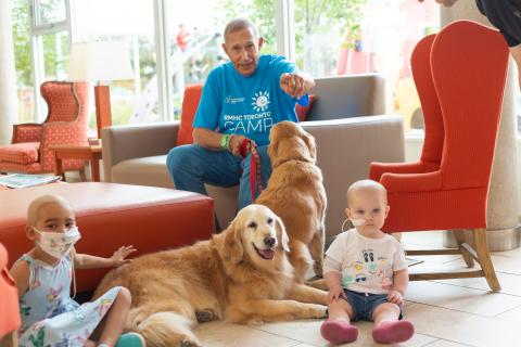 photo de George Cohon avec deux filles et deux chiens de thérapie